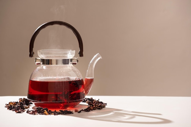 Red hibiscus tea from the petals of a Sudanese rose in a glass teapot