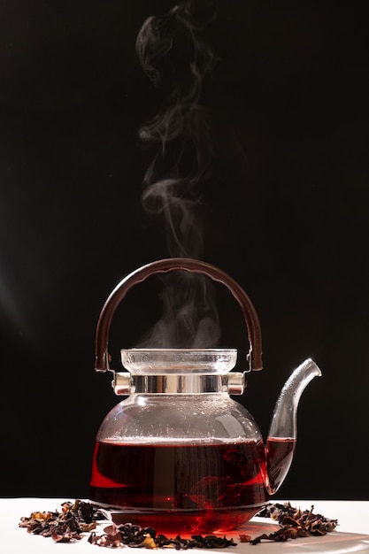 Red hibiscus tea from the petals of a Sudanese rose in a glass teapot