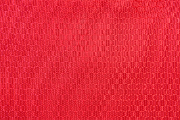 Red honeycomb background texture. Texture background of polyester fabric. Plastic weave fabric pattern