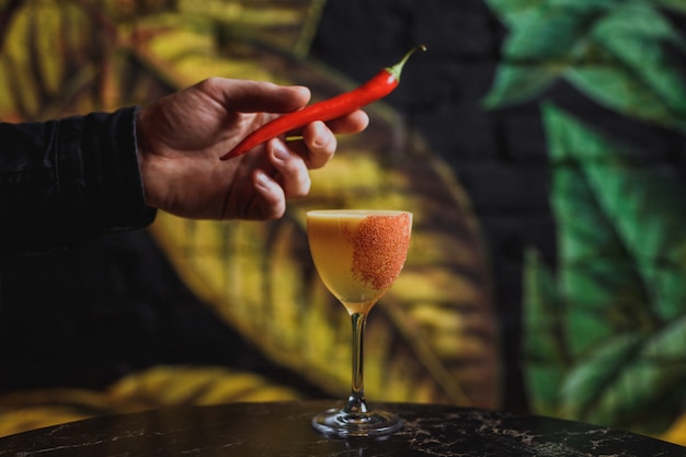 Red hot chili peper garnering zetten op een cocktailglas met een drankje