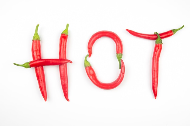 Photo red hot chili peppers are lined with letters on a white