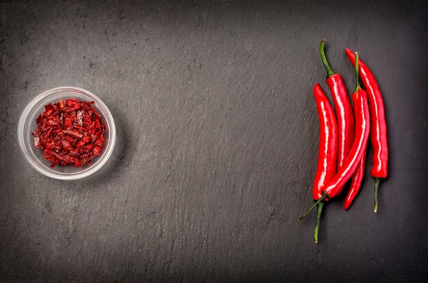 Red hot chili peppers on black stone background