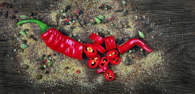 Red hot chili peppers and a mixture of different peppers on a wooden table. traditional spices.