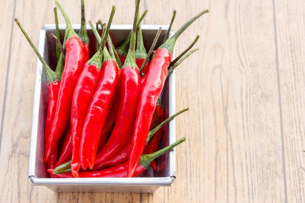 Red hot chili peppers on old wooden table with copy space for text