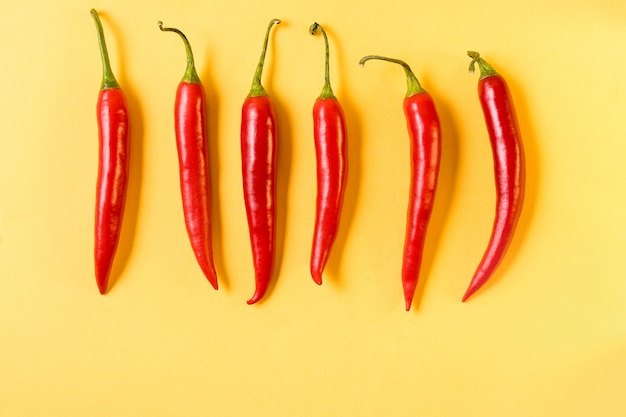 Red hot chili peppers pattern on yellow background,