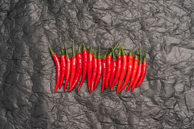 red hot chili peppers in a row on a black