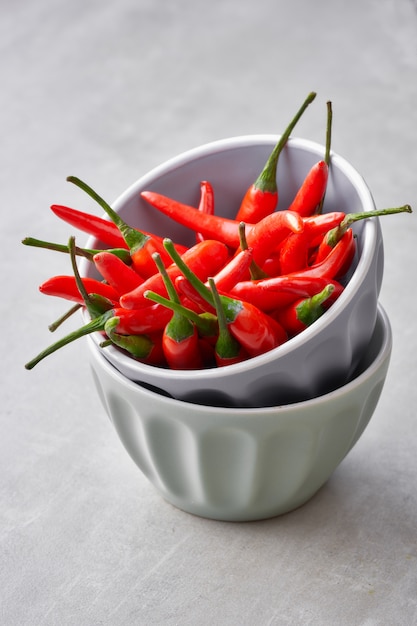 Red hot chili peppers in a stack of two grey ceramic bowls o