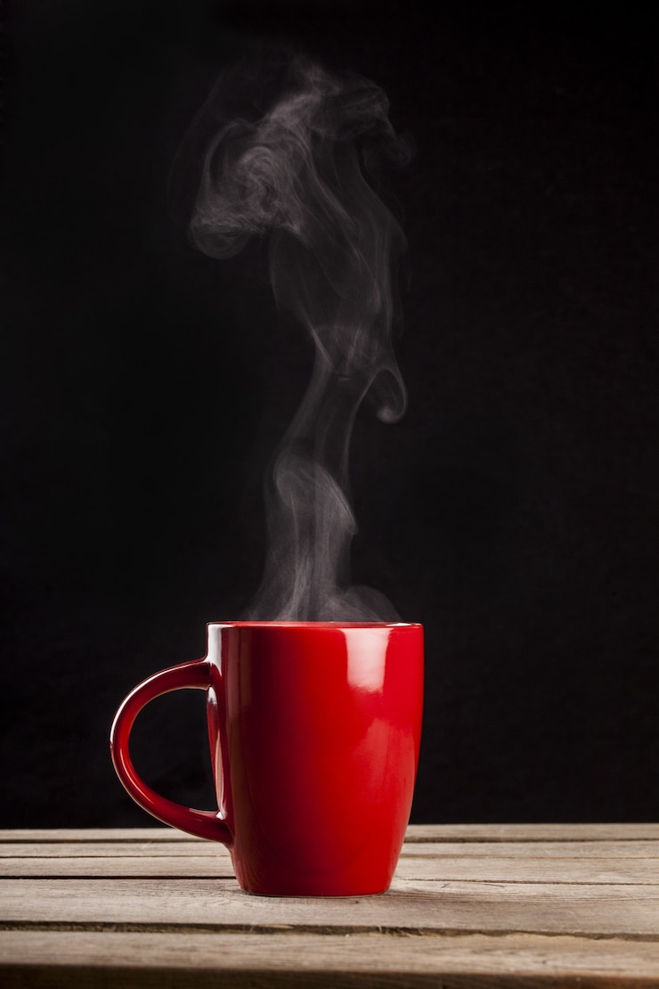 Photo red hot cup of coffee on black background
