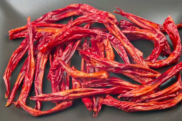 Red hot dried peppers in a market basket on a gray background