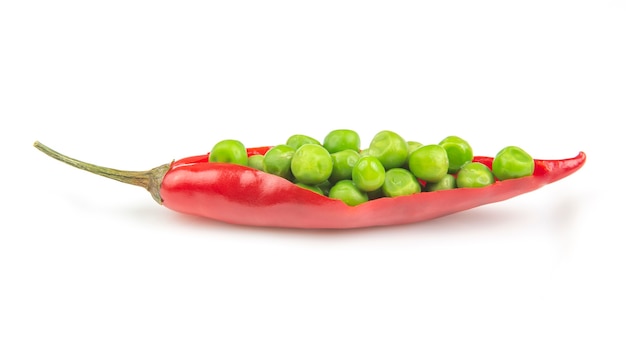 Фото Красный острый перец и зеленый горошек на белой тарелке. специи и овощи. острая пища и витамины
