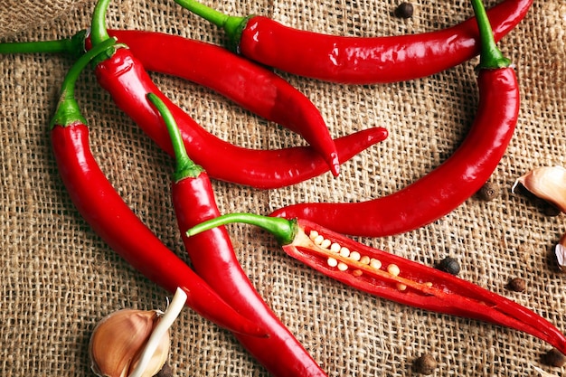 Red hot peppers with spices on table close up