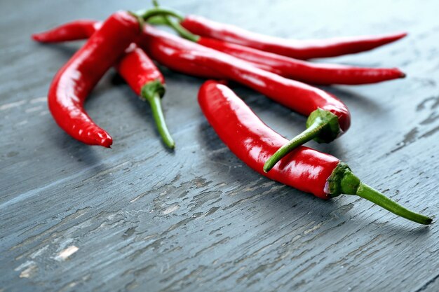 Red hot peppers on wooden table close up