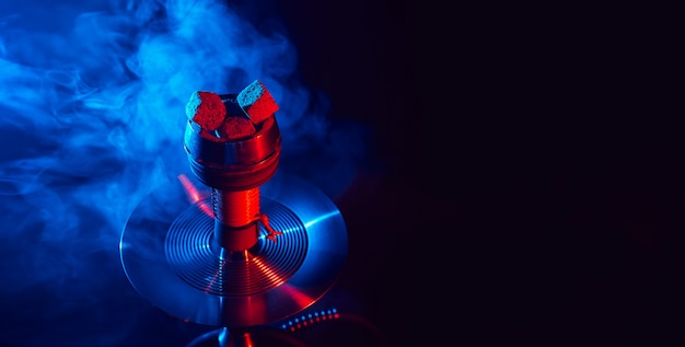Photo red hot shisha coals in a metal hookah bowl against a background of smoke