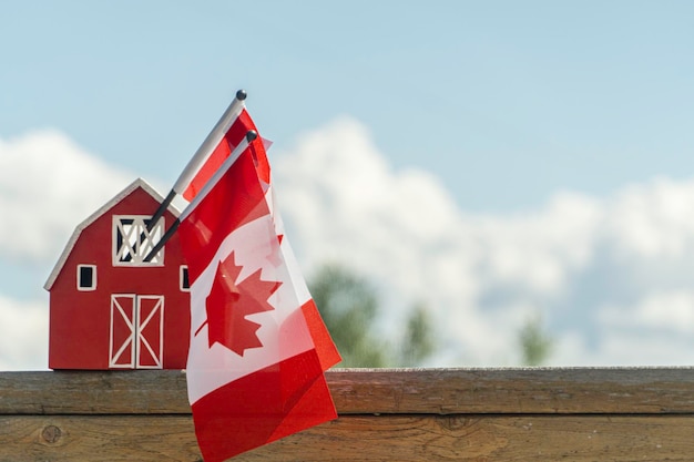 Red house with canadian maple leaf flag  canada day concept