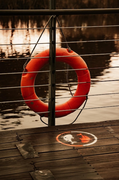Red inflatable ring on brown wooden dock photo