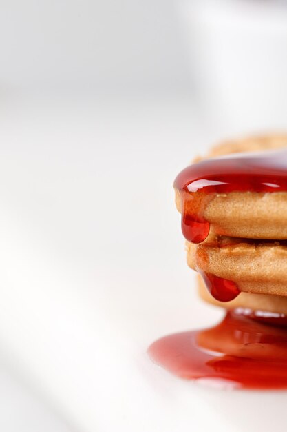 Red jam dripping pouring over cookies Close up delicious sweet jam Confiture