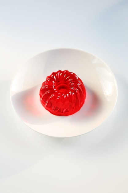 red jelly in a white porcelain dish on a white table