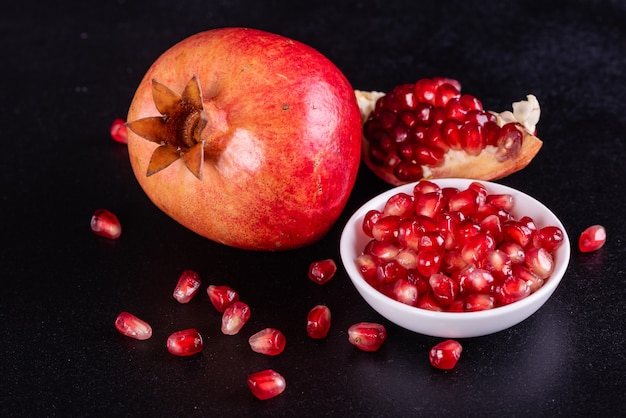 Red juice pomegranate on dark background