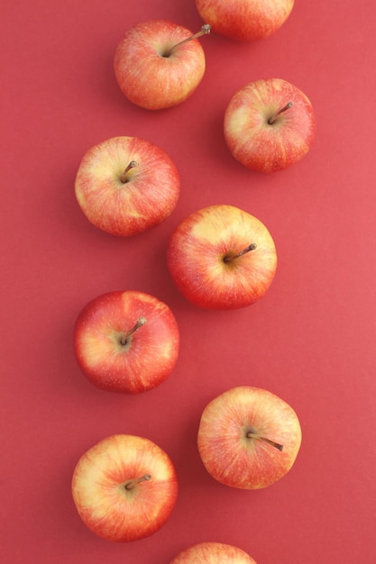 Красные сочные молодые вкусные яблоки на ярком ровном фоне