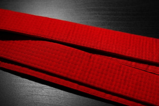 Red karate belt on dark background