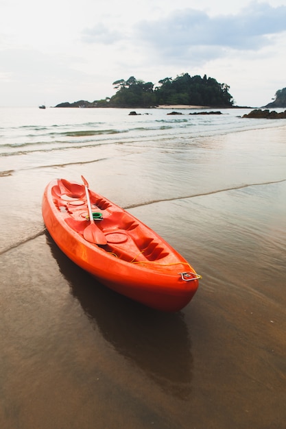 Photo red kayak at the beach in sunset.