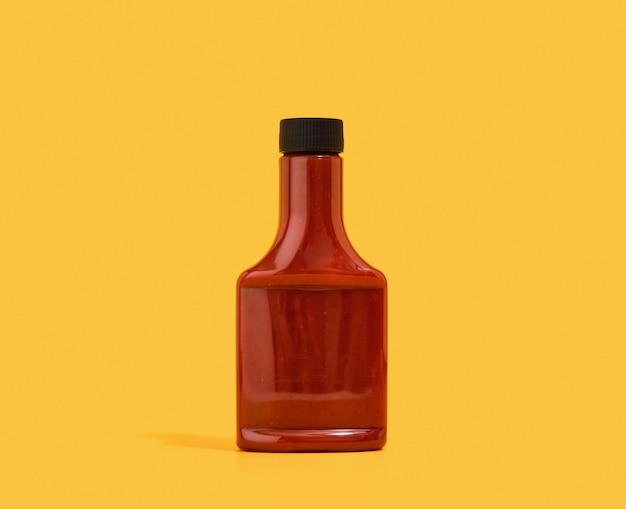 Photo red ketchup dispenser on a yellow background tasty dinner in modern restaurant