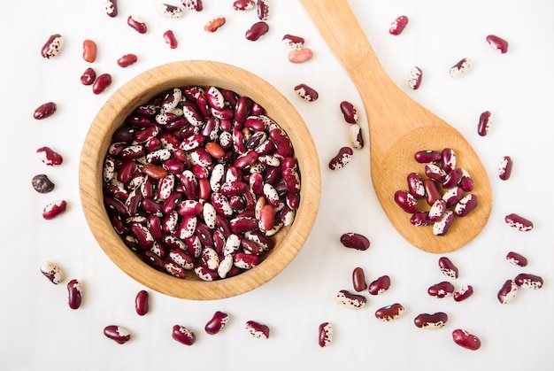 Red kidney beans. plate and spoon. White. Top view