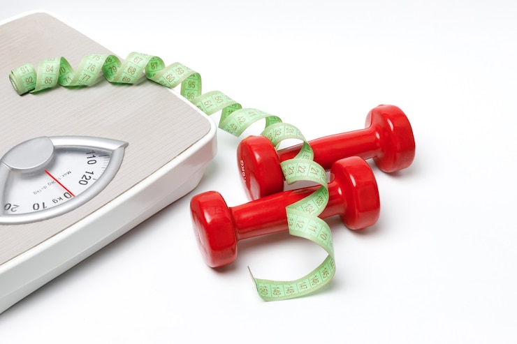 Photo red kilogram dumbbells, measuring tape and scales on a white background