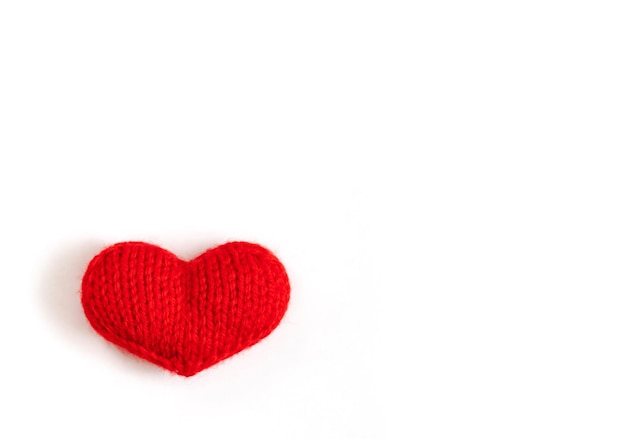 Красное вязаное сердце на белом фоне.