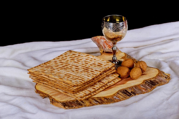 Matzah 또는 matza의 흰색 접시와 빈티지 나무 뒷면에 유월절 haggadah와 레드 코셔 와인