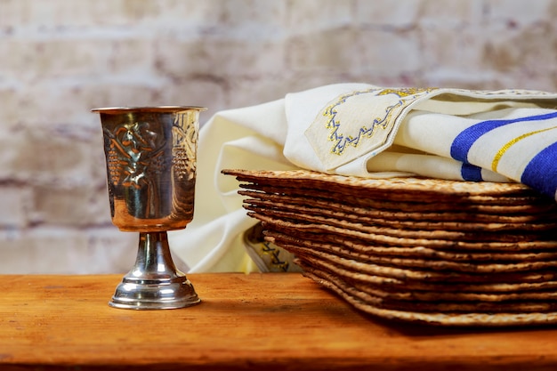 Foto vino rosso kosher con un piatto bianco di matzah o matza e una haggada pasquale