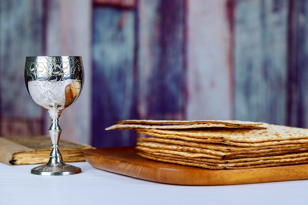 Vino rosso kosher con un piatto bianco di matzah o matzo e una haggada pasquale