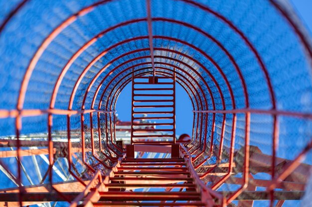 Red ladder for climbing the communication tower with a hatch