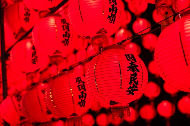 Photo red lanterns hanging up in the night, the chinese words on lantern means praying