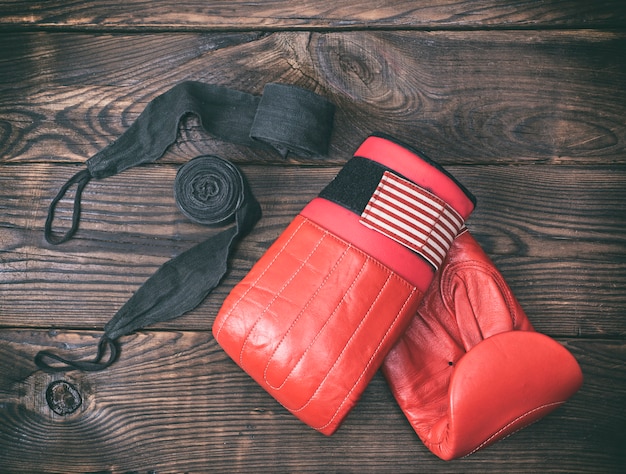 Red leather boxing gloves and black bandage