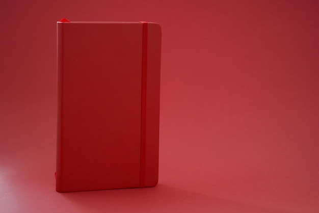 Red leather diary book on red background