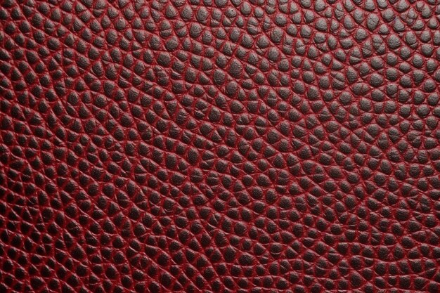 A red leather texture with a pattern of small scales.