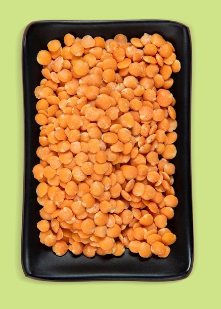 Red lentil in bowl isolated on pink background Top view