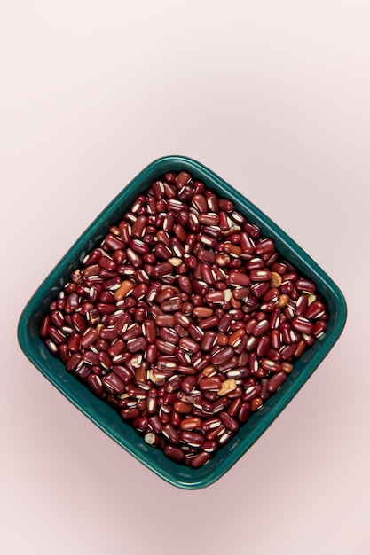 Red lentil in bowl isolated on pink background Top view