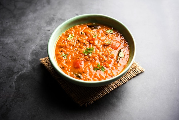 Red Lentil Cooked Dal or Dhal or Masoor daal tadka served in a bowl, selective focus