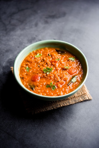 Red Lentil Cooked Dal or Dhal or Masoor daal tadka served in a bowl, selective focus