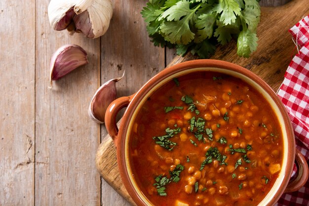 Red lentil soup in bowl on rustic wooden table