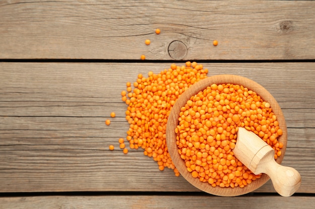 Red lentils in a wooden spoon and bowl