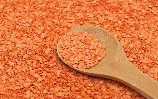 Red lentils on wooden spoon