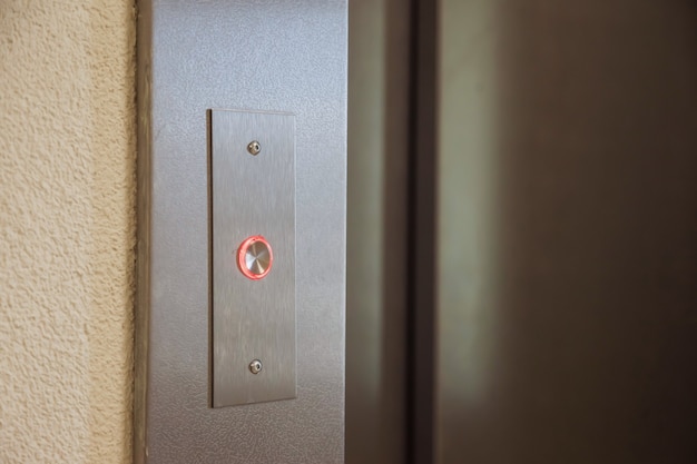 Luce rossa sul pulsante dell'ascensore in un edificio residenziale di appartamenti. pulsanti per chiamare l'ascensore in un condominio. movimento, concetto di trasporto. un sacco di pulsanti sul muro. copia spazio