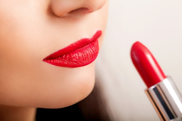 Rossetto rosso. primo piano del volto di donna con rossetto rosso brillante opaco sulle labbra carnose. cosmetici di bellezza, concetto di trucco. immagine ad alta risoluzione