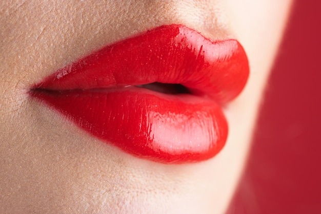 写真 ふっくらとした自然な唇のための赤い口紅の光沢のあるメイクアップ 口紅とポマードをクローズアップ赤い唇ピンク