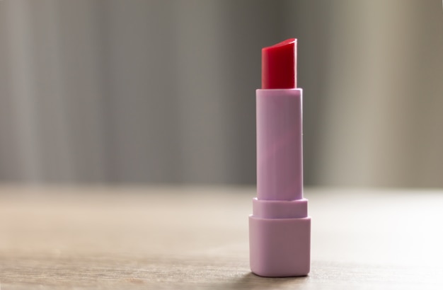 Photo a red lipstick is placed on a wooden table