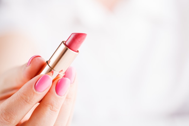 Red lipstick in a woman's hand