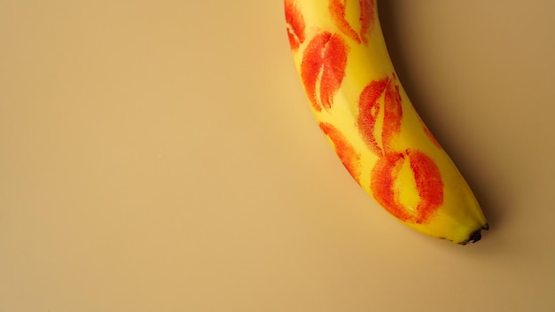 Red lipstick on a yellow banana on a golden background.